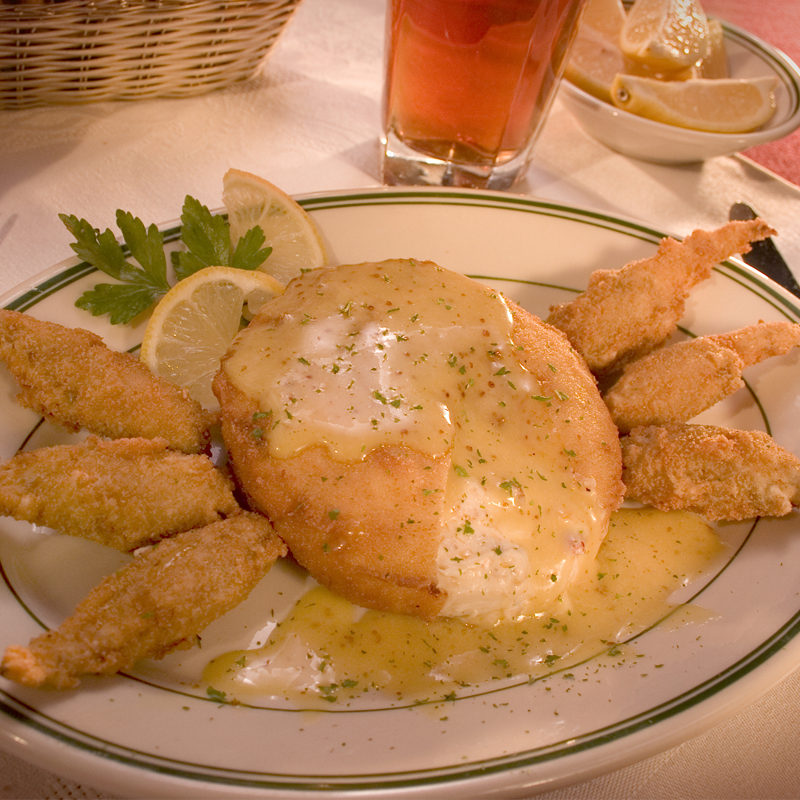 image of a plated crab cake with fried crab claws